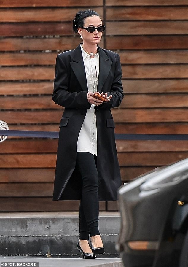 Katy Perry looked smart in black leggings, a long white button-up shirt and a knee-length black coat as she shopped in Los Angeles this week