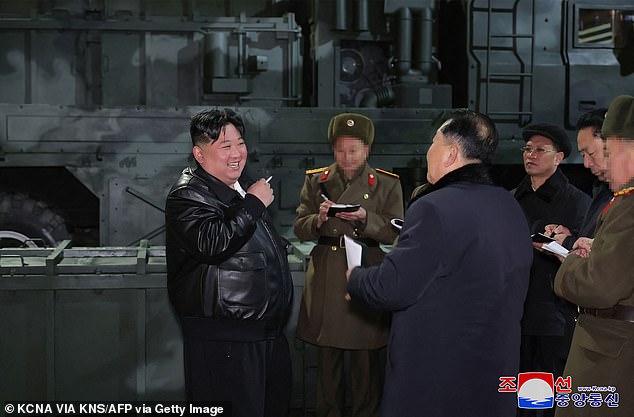 Images in state media showed Kim, wearing a long black leather jacket and holding a cigarette, standing in front of what analysts said were short-range ballistic missile launchers.  The missiles are reportedly nuclear capable