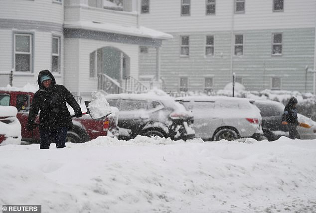 A woman throws snow while shoveling snow in Worcester, Massachusetts, on Sunday