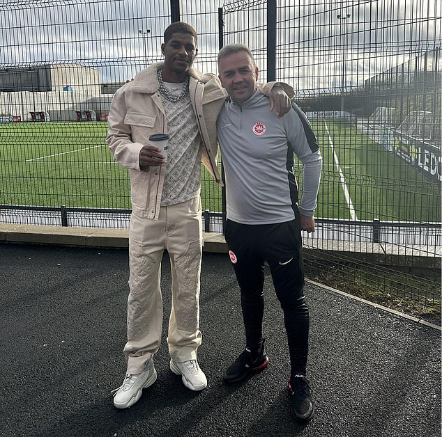 Rashford visited the training ground of NIFL Premiership side Larne on Thursday.  He is pictured next to head of recruitment Gerry Flynn