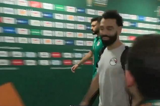 Salah can be seen smiling as he walks through the tunnel where the press gathered