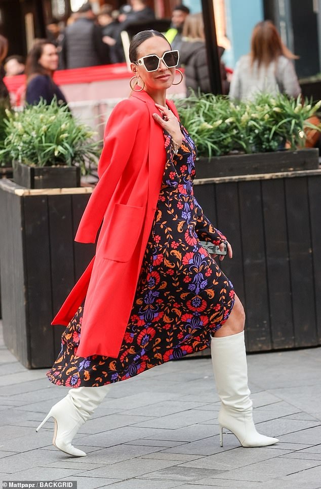 The radio host, 45, turned heads with the floral number which she paired with a statement red maxi coat