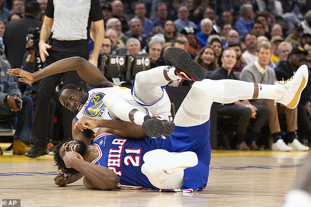 Joel Embiid winces in pain during his comeback game against the Golden State Warriors