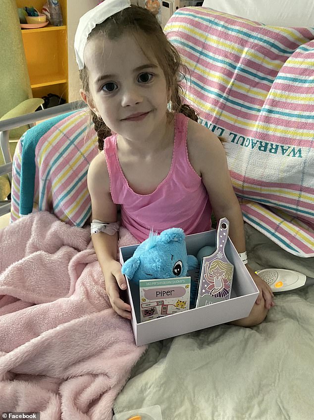 Piper sits up in her hospital bed, holding a gift she received from one of her doctors, including a replacement for a favorite brush her mother couldn't find