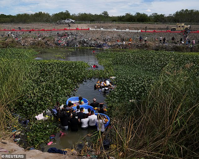 People cross the Rio Grande River to turn themselves in to authorities in Brownsville, Texas, to begin their immigration process, seen from Matamoros, Mexico