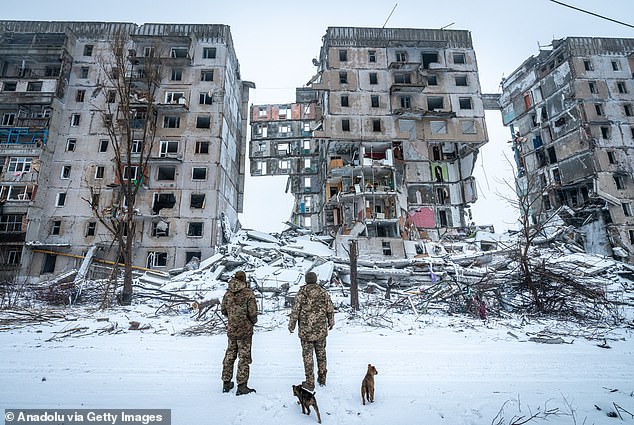 Ukrainian soldiers stand in front of a building destroyed by a Russian missile attack as the war between Russia and Ukraine continues in Donetsk Oblast