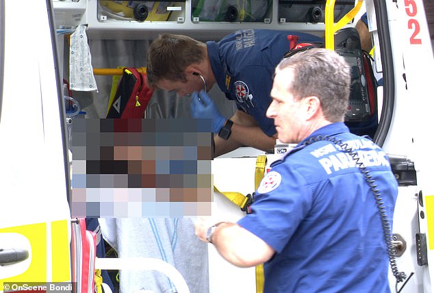 A woman was allegedly stabbed with a paint scraper in Sydney's eastern suburbs, with a 25-year-old man arrested over the attack (pictured, woman in an ambulance)