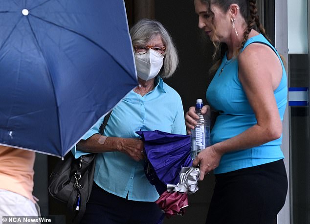 An elderly couple crashed into luxury cars in broad daylight in a fit of road rage, a court has been told.  Barbara Edwards, 70, is pictured as family members tried to protect her with an umbrella