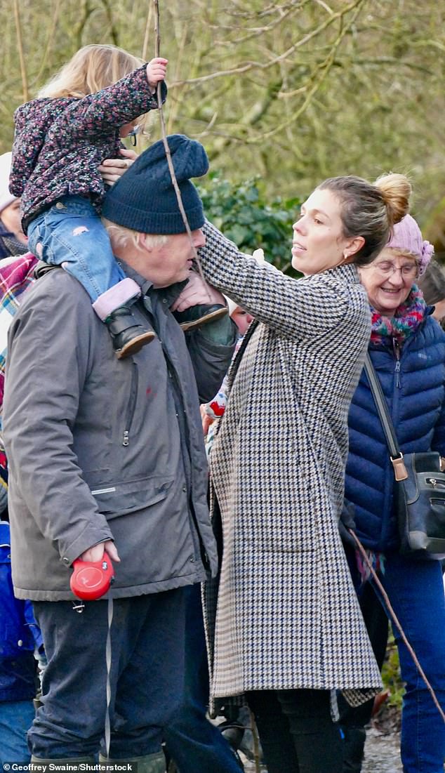 The former Prime Minister was seen walking his dog Dilyn while carrying one of his young children on his shoulders, alongside his wife Carrie