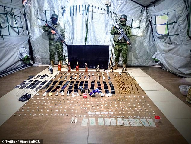 Ecuadorian soldiers display bottles of liquor, cellphones, watches and drugs seized at prison in central Cotopaxi province