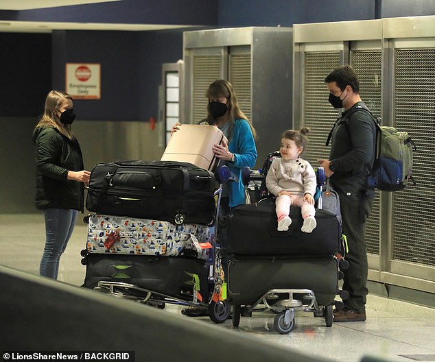 Bindi Irwin, 25, Terri Irwin, 59, Chandler Powell, 27, and daughter Grace, two, landed at LAX on Sunday.  Little Grace enjoyed sitting on bags stacked on a luggage cart