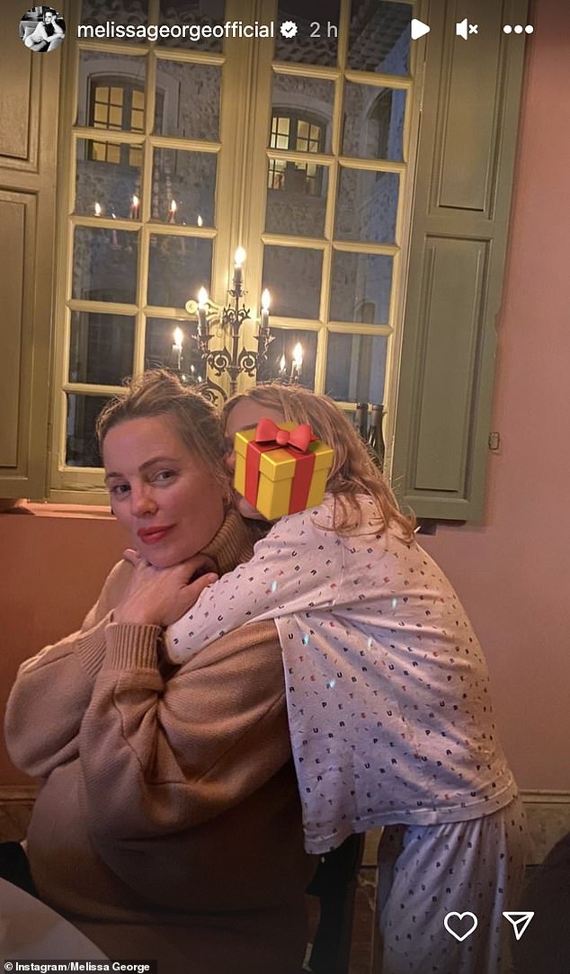 Melissa George shocked fans on Thursday when she showed off a visible bump while on holiday with her kids