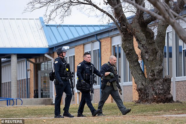 Law enforcement officers work the scene of a shooting at Perry High School in Perry, Iowa