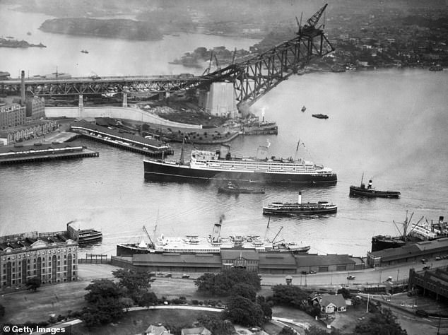 The two pairs of 89-meter-high towers, which stood on either side of the monument, were not part of the original design.  The granite blocks were added later to reassure the public that it would fall.  The Sydney Harbor Bridge is pictured under construction in 1930