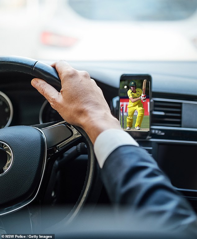 The male motorist was spotted driving in North Parramatta watching the cricket in full screen on his phone in a holder on the dashboard to the right of the steering wheel (stock image)