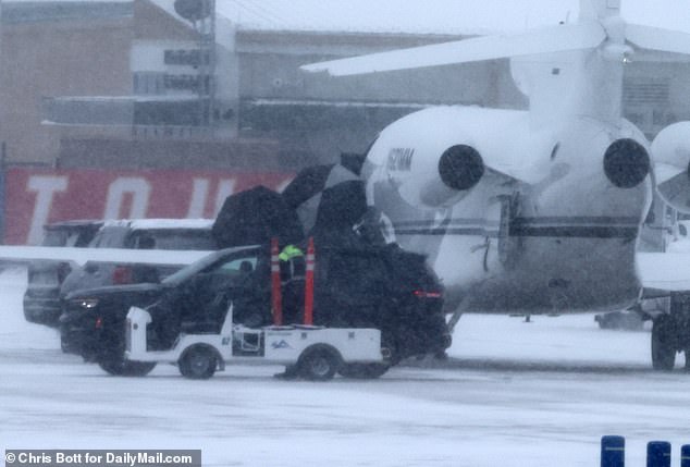 The 34-year-old billionaire shielded her face from the Arctic winds with an umbrella as she exited the plane at Charles B. Wheeler Downtown Airport