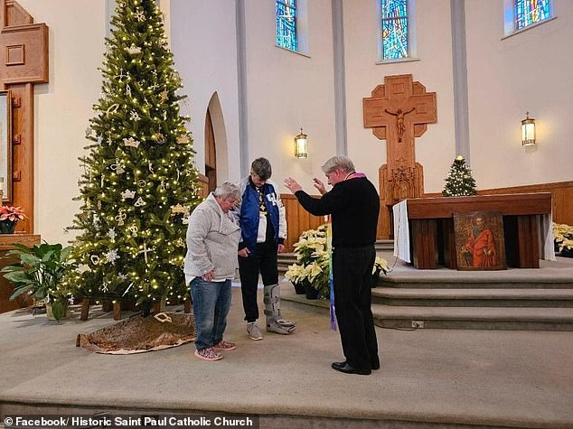 Wearing a long rainbow-colored scarf, the Very Rev. Richard Watson blessed the couple on Dec. 31 at Historic Saint Paul Catholic Church in Lexington.