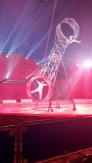 The act involves two performers moving two connected wheels in a circle