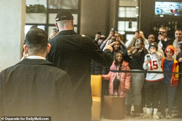 Travis Kelce showed the peace sign to cheering fans at the Chiefs hotel on Sunday