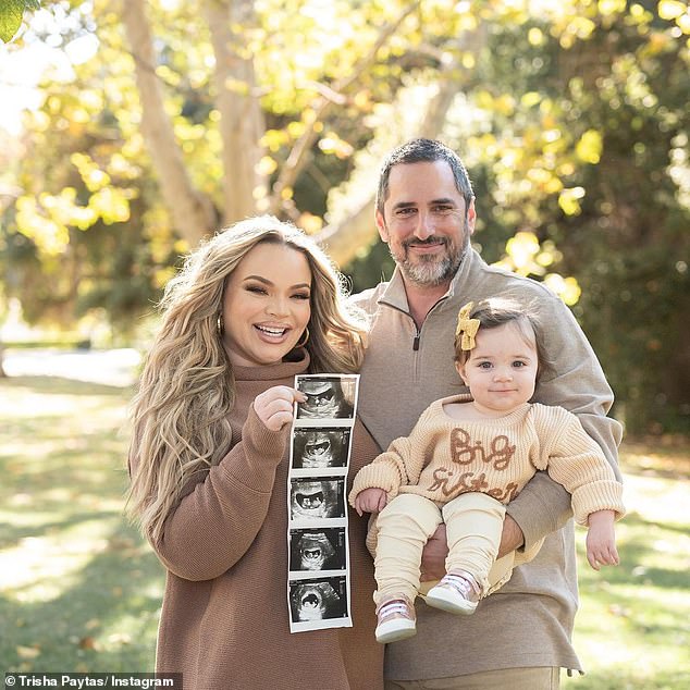 Family is everything: Moses wore a coordinating look consisting of tan pants with a beige-hued half-zip sweater