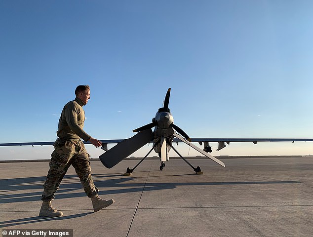 A photo taken on January 13, 2020 shows a member of the US Armed Forces walking past a drone at Ain al-Asad Air Base in Iraq's western Anbar province