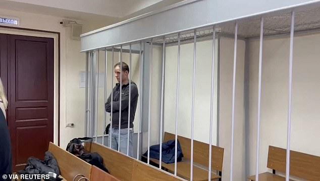 Evan Gershkovich, 32, stands in a room for defendants during a court hearing in Moscow