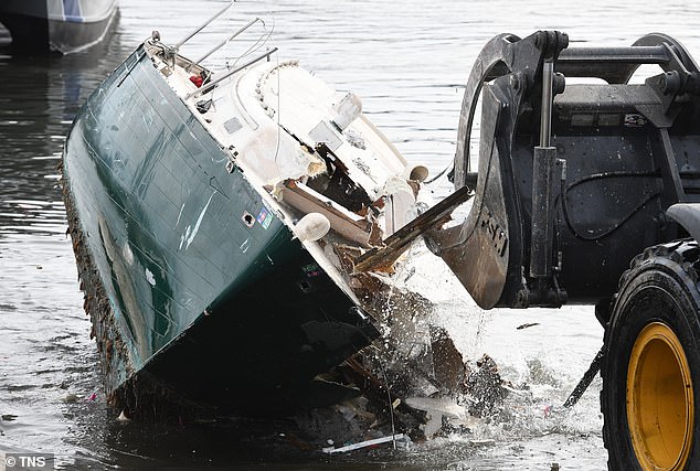 A front-end loader breaks an abandoned boat out of the waters of Oakland's Alameda Estuary in Oakland in December.  The Oakland Police Marine unit removed the boats from shore and towed them to the parking lot of the Jack London Aquatic Center where they were destroyed