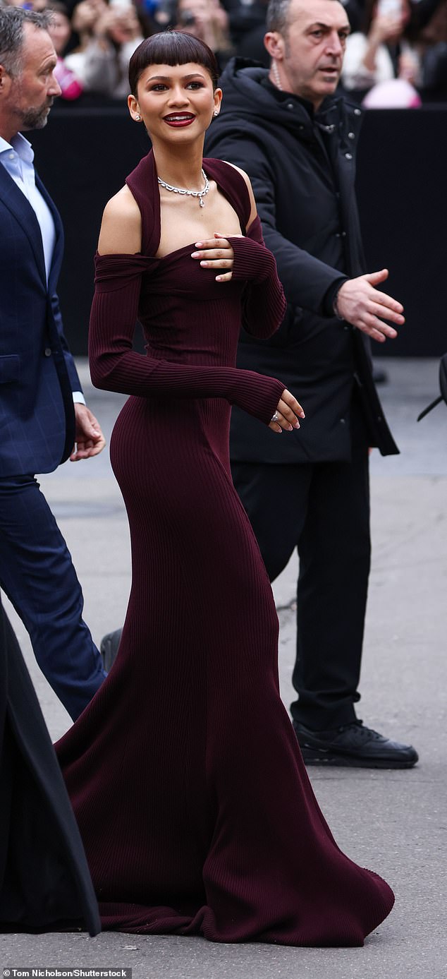 Upon arriving at the event, Zendaya wore a burgundy off-the-shoulder, long-sleeved glove-style dress with a halter neck finish