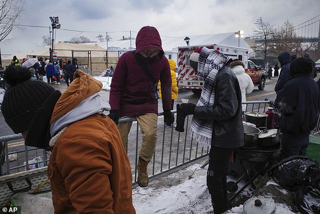 Migrants gather outside a shelter on Randall's Island on January 19