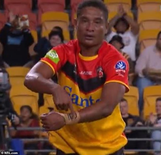 The PNG star points to a message on her wrist after scoring her country's only try against Australia