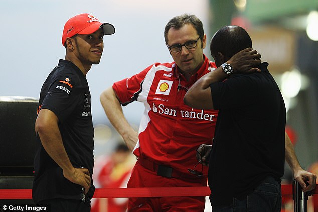 Hamilton and his father Anthony (right) chat with then Ferrari team boss Stefano Domenicali during the 2011 Malaysian Grand Prix