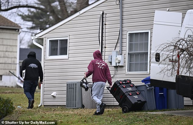 Two men wearing protective gear were seen entering the back of the house Thursday morning with heavy cleaning products