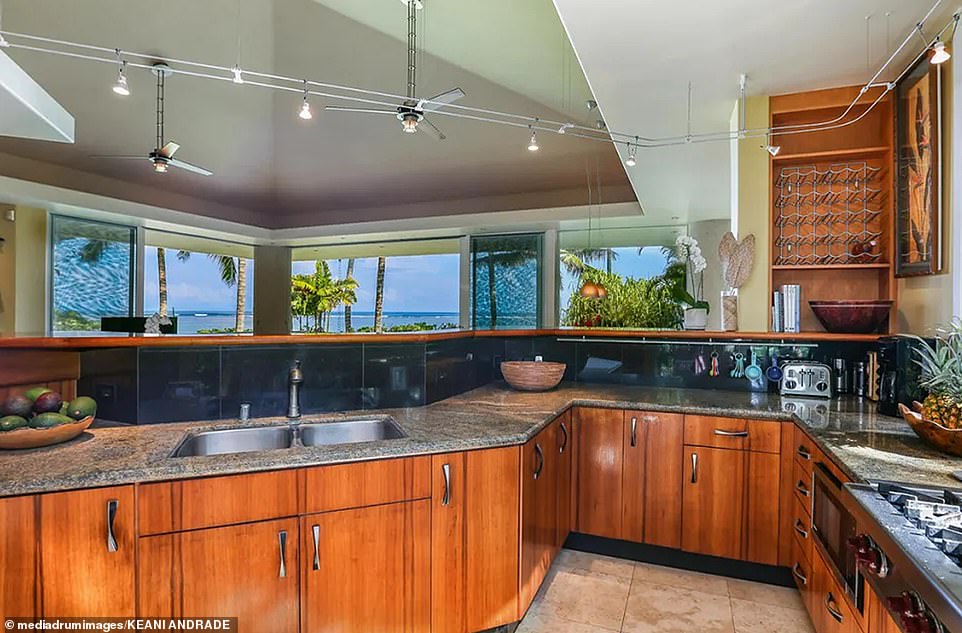 Designed by architect Norman Lacayo, it features a unique wooden front door, an open layout, floor-to-ceiling windows, custom cabinetry and tropical landscaping.