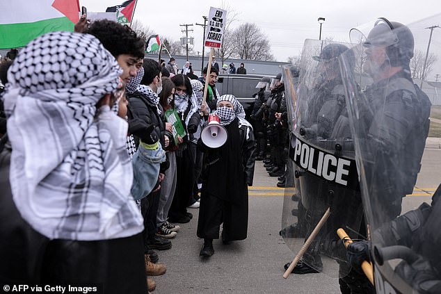 Protesters were surrounded by riot police as they shouted: 'Biden Biden can't you see, you're on a killing spree'