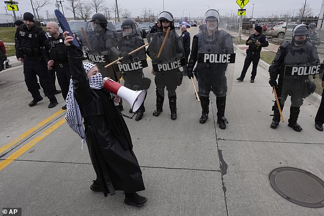 A pro-Palestinian protester marches near police during Biden's visit