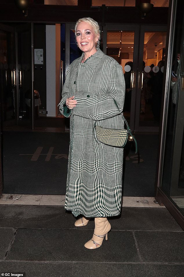 She looked chic in a long patterned trench coat, which she paired with a matching handbag