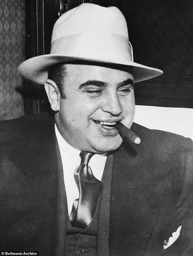 840 SEI*189648967 Notorious gangster Al Capone smokes a cigar on the train taking him to the federal prison in Atlanta, where he began serving his eleven-year sentence