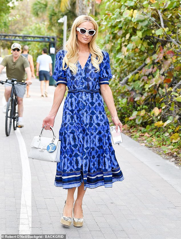 The socialite looked stunning in a striking blue dress with a Louis Vuitton bag on her arm