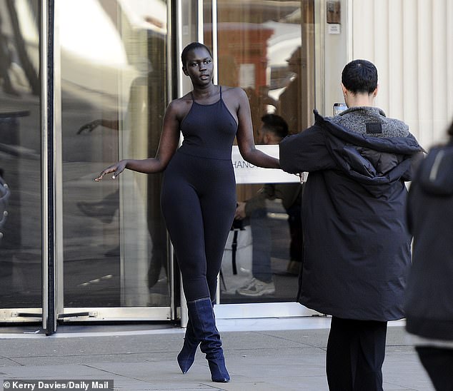 A model struts her stuff outside the revolving doors of the iconic building