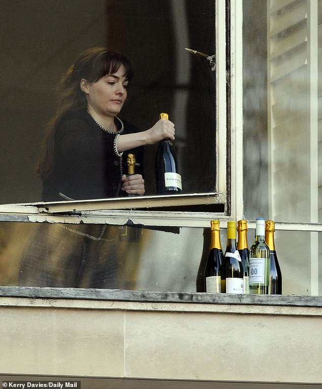 An employee places champagne and wine on the windowsill to keep it cool before a giant toast