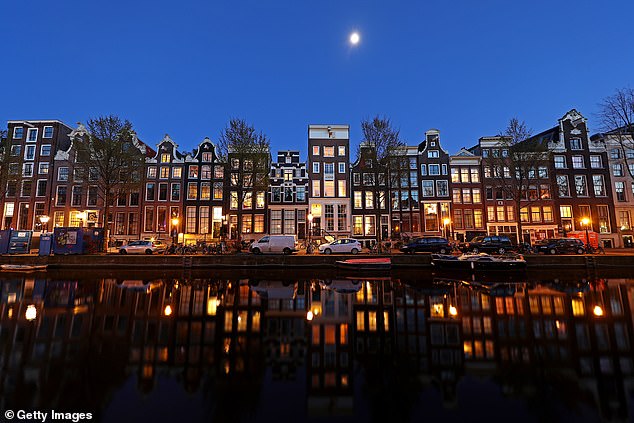 Amsterdam plans to eventually close its century-old Red Light District, the Red Light District, known for the neon-lit windows in which sex workers stand as they try to lure customers (file image)