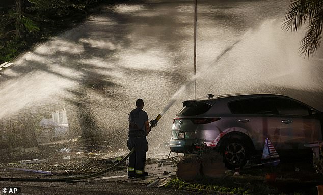 Firefighters destroy hotspots after a small plane crashed into a mobile home on Thursday