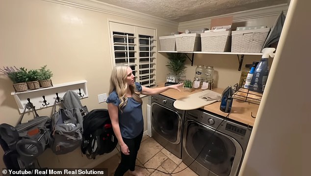 The kitchen leads to the first of two laundry rooms in the house, with large laundry units and a wall-mounted chest of drawers