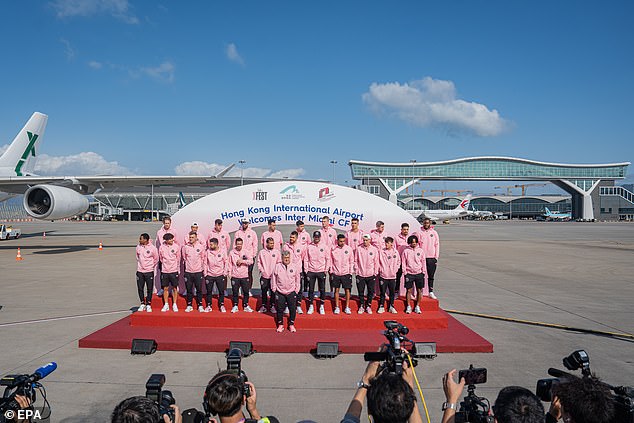 The crew posed for a photo on the airport tarmac as a horde of photographers waited