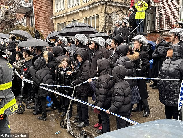 A crowd of concerned residents gathered behind the police cordon to see what was happening