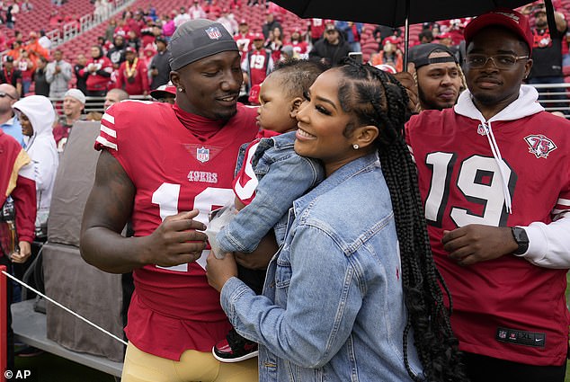 Deebo Samuel, left, and Mahogany Jones hold their child, Tyshun Raequan Samuel Jr., before a 2022 game