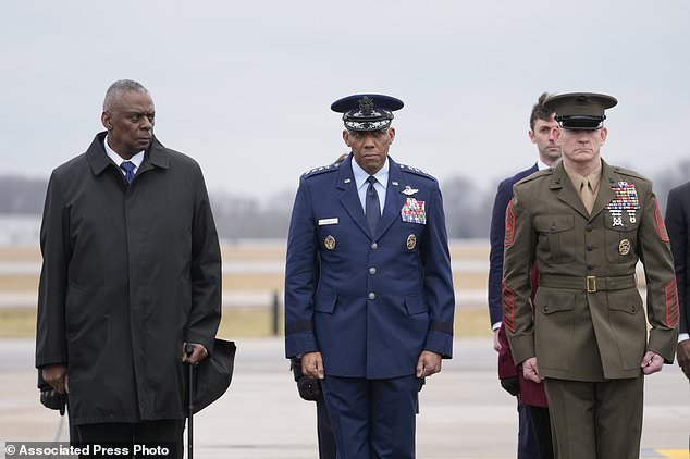 Defense Secretary Lloyd Austin (left), Chairman of the Joint Chiefs of Staff Gen. CQ Brown and Marine Corp.  Sgt.  Maj. Troy E. Black watches as an Army transport team moves the flag-draped transfer bin containing the remains of three service members killed in an Iran-backed attack