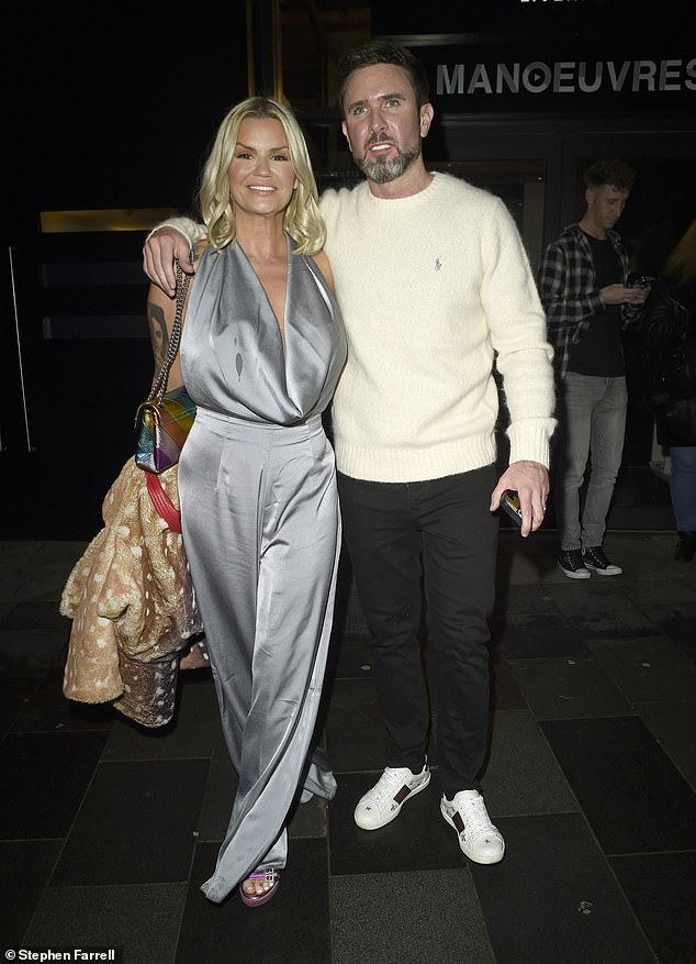 Looking dapper in a white sweater and smart trousers, Kerry's fiancée, fitness instructor, Ryan Mahoney, put his arm around his wife to show love