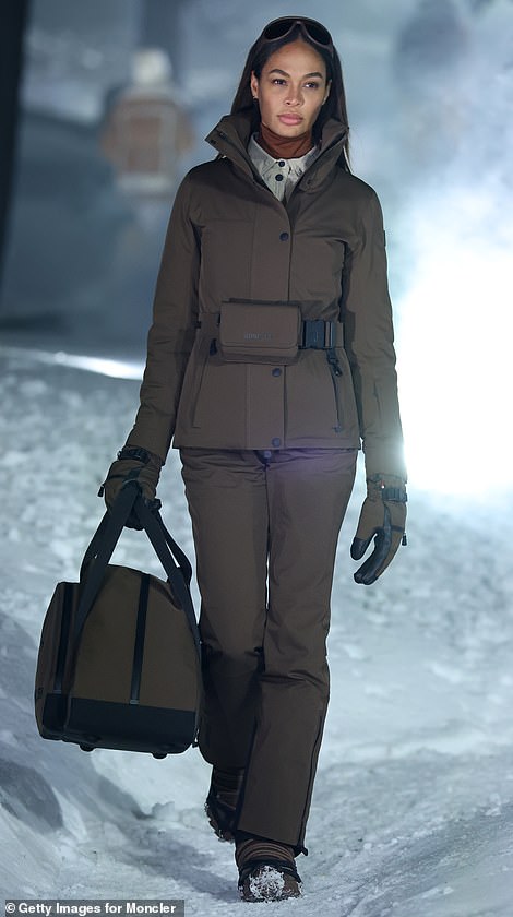 Joan wore a stylish dark brown button-up jacket and matching trousers and completed her ensemble with a roomy bag and ski goggles