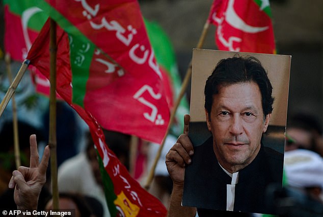 An activist from the opposition Pakistan Tehreek-e-Insaf (PTI) party holds a portrait of Pakistan's former Prime Minister Imran Khan during an anti-government rally on October 28, 2022